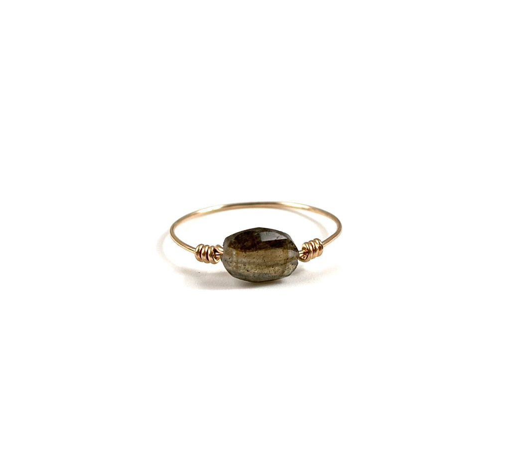 Cette bague met en valeur une petite pierre fine ovale facettée, dont les reflets naturels apportent lumière et délicatesse au bijou.

La pierre est délicatement maintenue par un fil en gold filled 14 carats, formant un design fin et épuré qui souligne la beauté de la pierre.